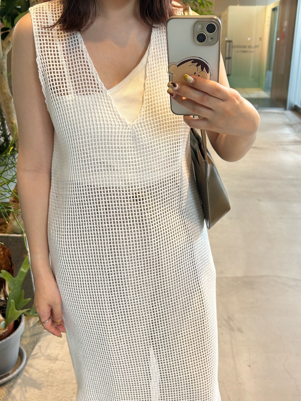 ブラウン系のショルダーバッグ、ブラウン系のサンダルを着用したレディースの春コーディネートの4枚目の写真