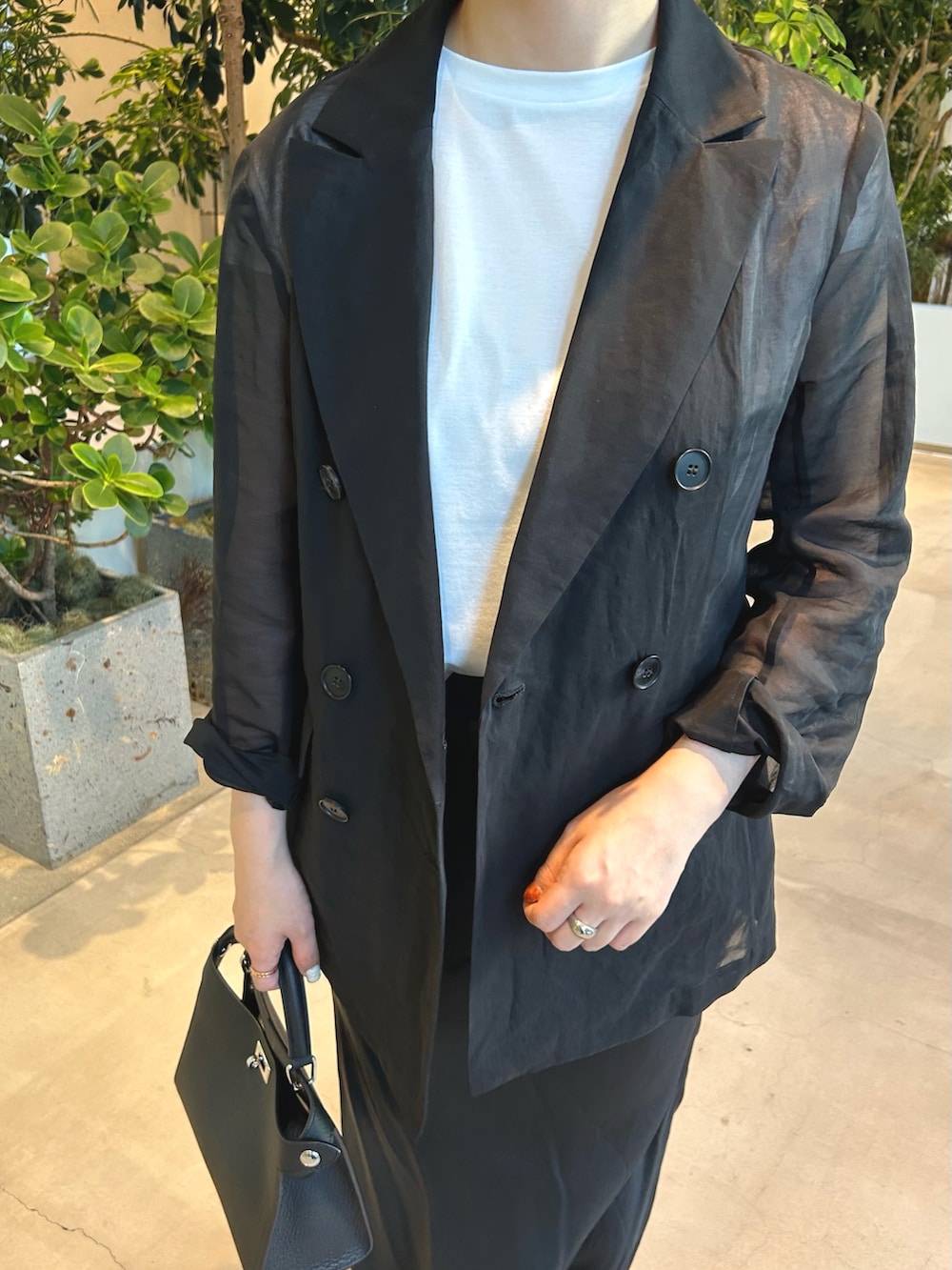 ブラック系のパンプス、ブラック系のテーラードジャケットを着用したレディースの春コーディネートの4枚目の写真