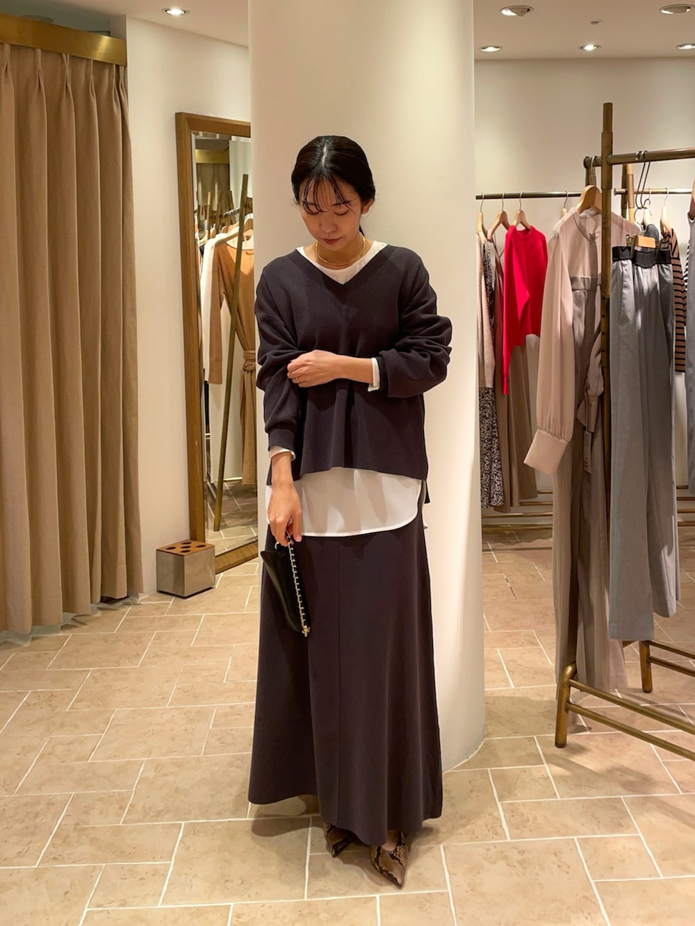 ホワイト系のシャツ/ブラウス、グレー系のニット/セーター、グレー系のスカートを着用したレディースの冬コーディネートの3枚目の写真