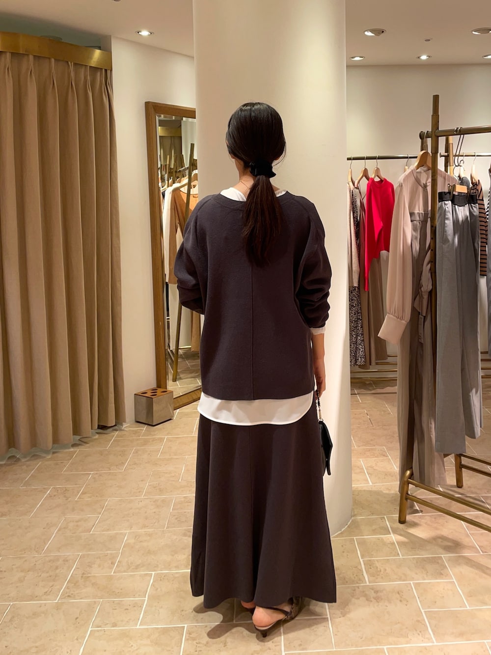 ホワイト系のシャツ/ブラウス、グレー系のニット/セーター、グレー系のスカートを着用したレディースの冬コーディネートの4枚目の写真