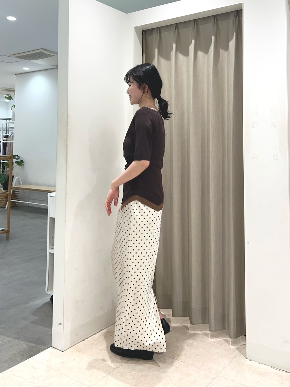 ブラウン系のニット/セーター、ホワイト系のスカート、ブラック系のローファーを着用したレディースの春コーディネートの2枚目の写真