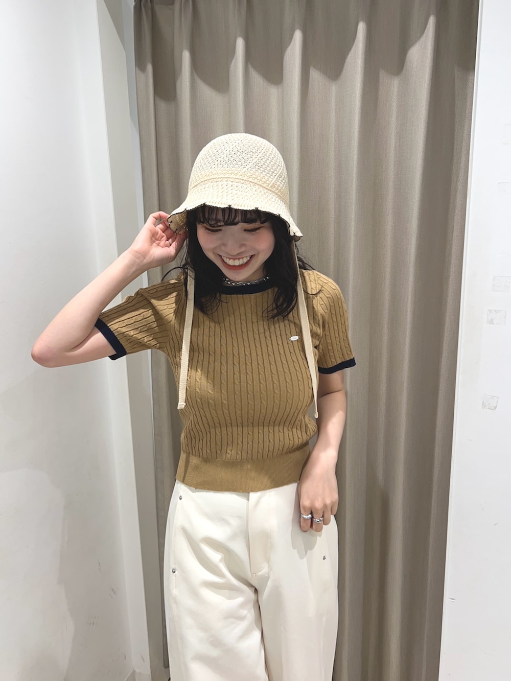 ベージュ系のニット/セーター、ホワイト系のその他パンツ、ホワイト系のハットを着用したレディースの夏コーディネートの3枚目の写真