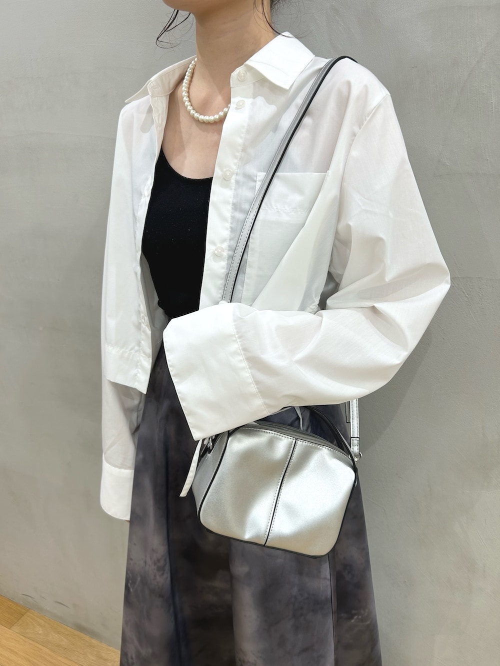 ブラック系のスカート、ホワイト系のシャツ/ブラウス、シルバー系のショルダーバッグを着用したレディースの春コーディネートの3枚目の写真