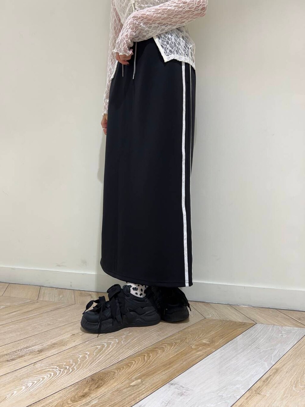 ブラック系のスカート、ホワイト系のTシャツ/カットソーを着用したレディースの秋コーディネートの3枚目の写真