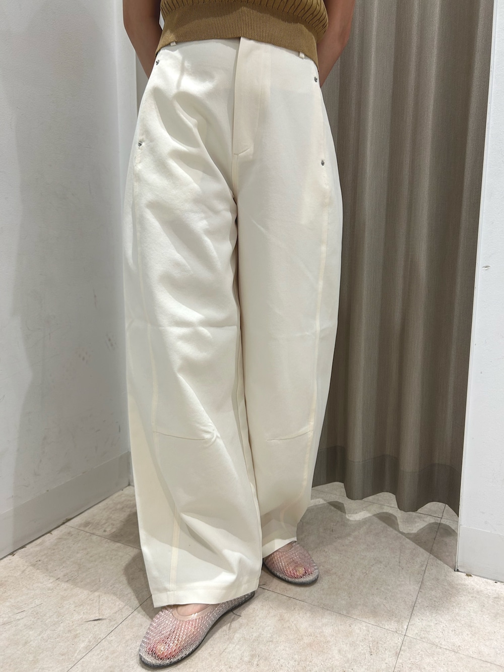 ベージュ系のニット/セーター、ホワイト系のその他パンツ、ホワイト系のハットを着用したレディースの夏コーディネートの4枚目の写真