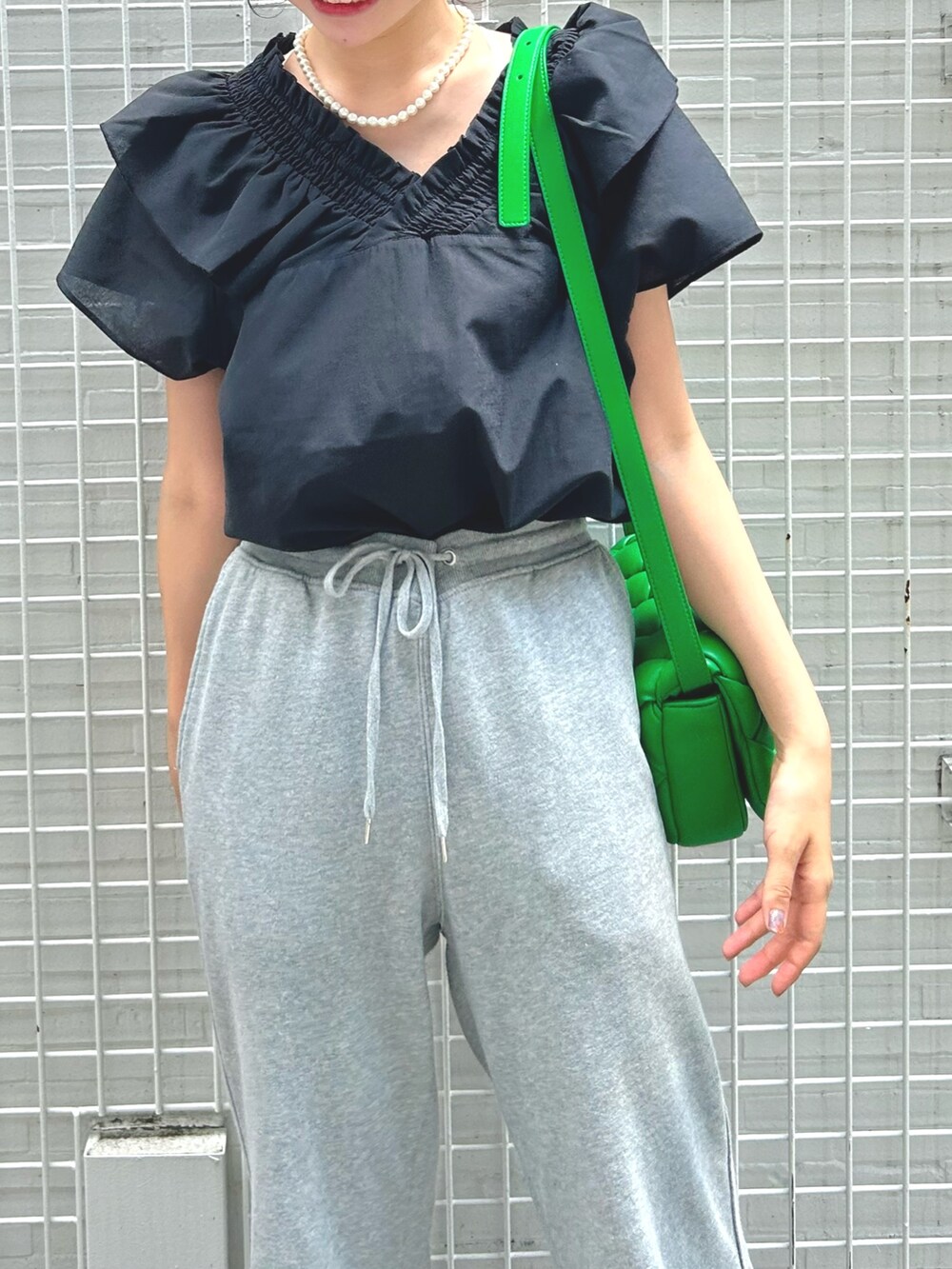 ブラック系のシャツ/ブラウス、ホワイト系のネックレスを着用したレディースの夏コーディネートの2枚目の写真