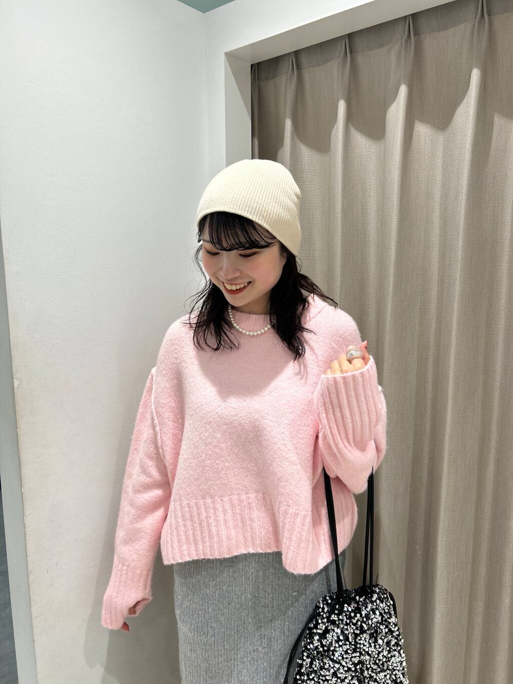 シルバー系のトートバッグ、グレー系のスカート、ブラック系のブーツを着用したレディースの冬コーディネートの3枚目の写真