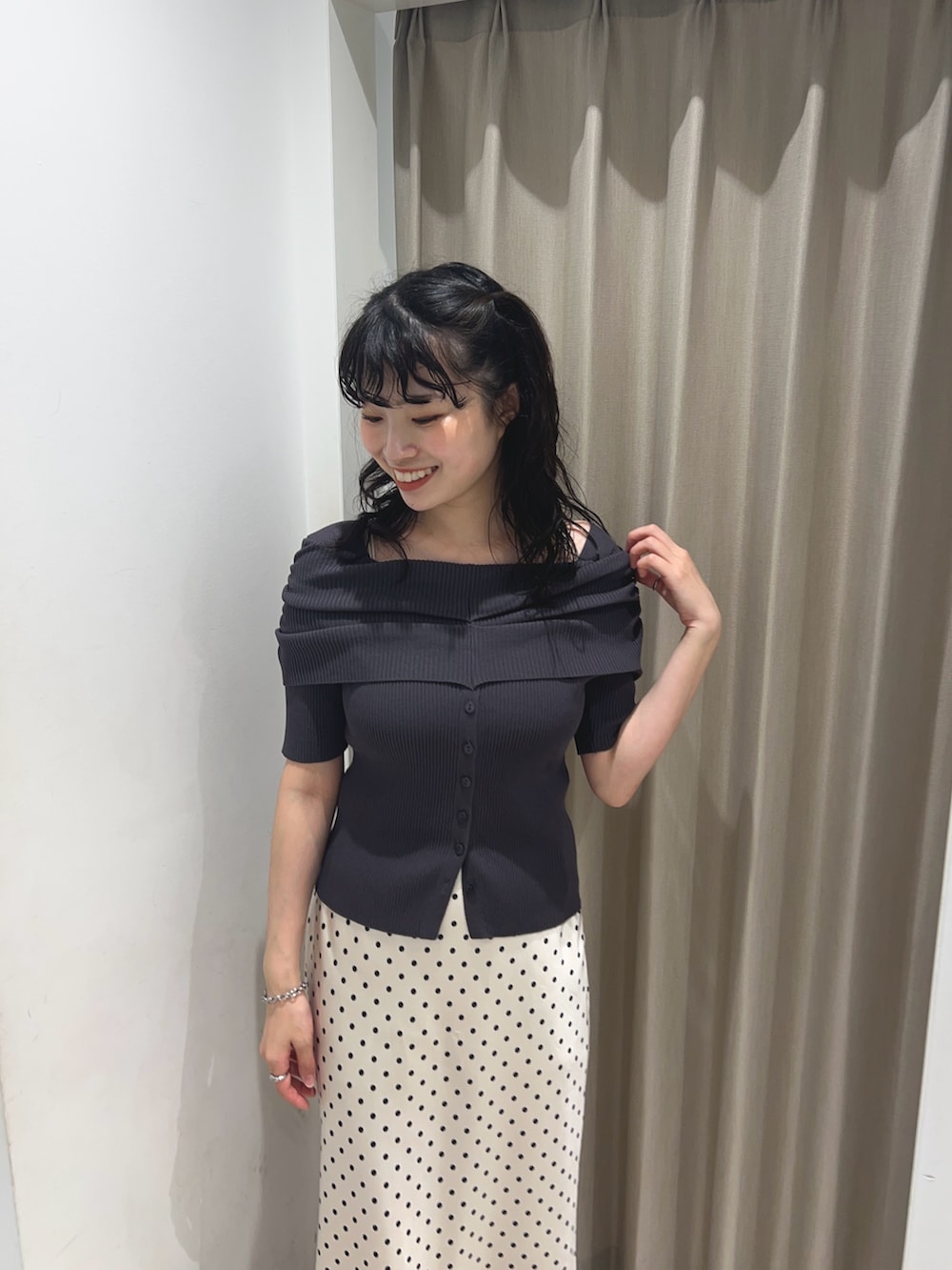 グレー系のニット/セーター、ホワイト系のスカートを着用したレディースの夏コーディネートの3枚目の写真