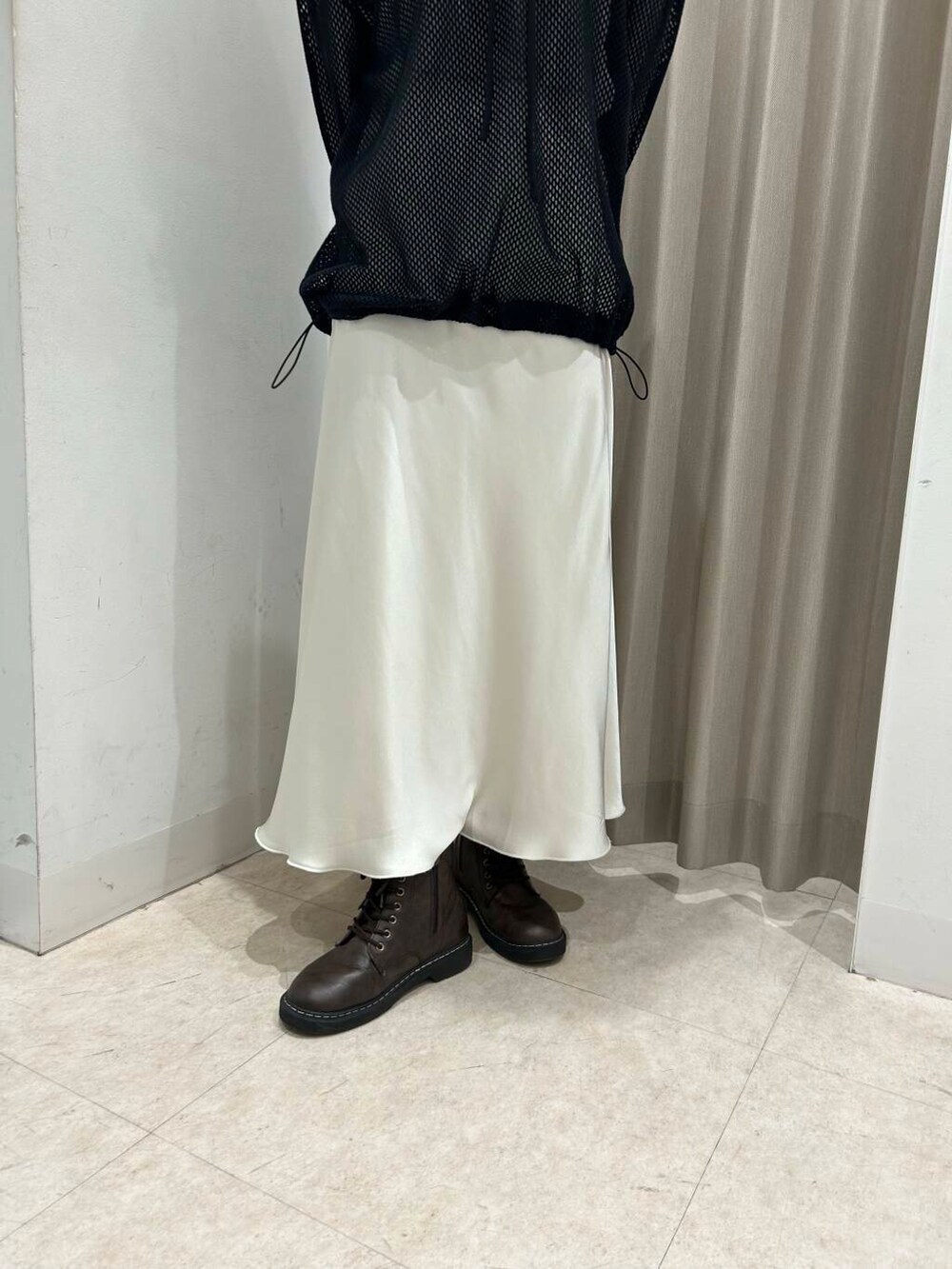 ホワイト系のスカート、ホワイト系のTシャツ/カットソー、ブラック系のその他トップスを着用したレディースの春コーディネートの4枚目の写真