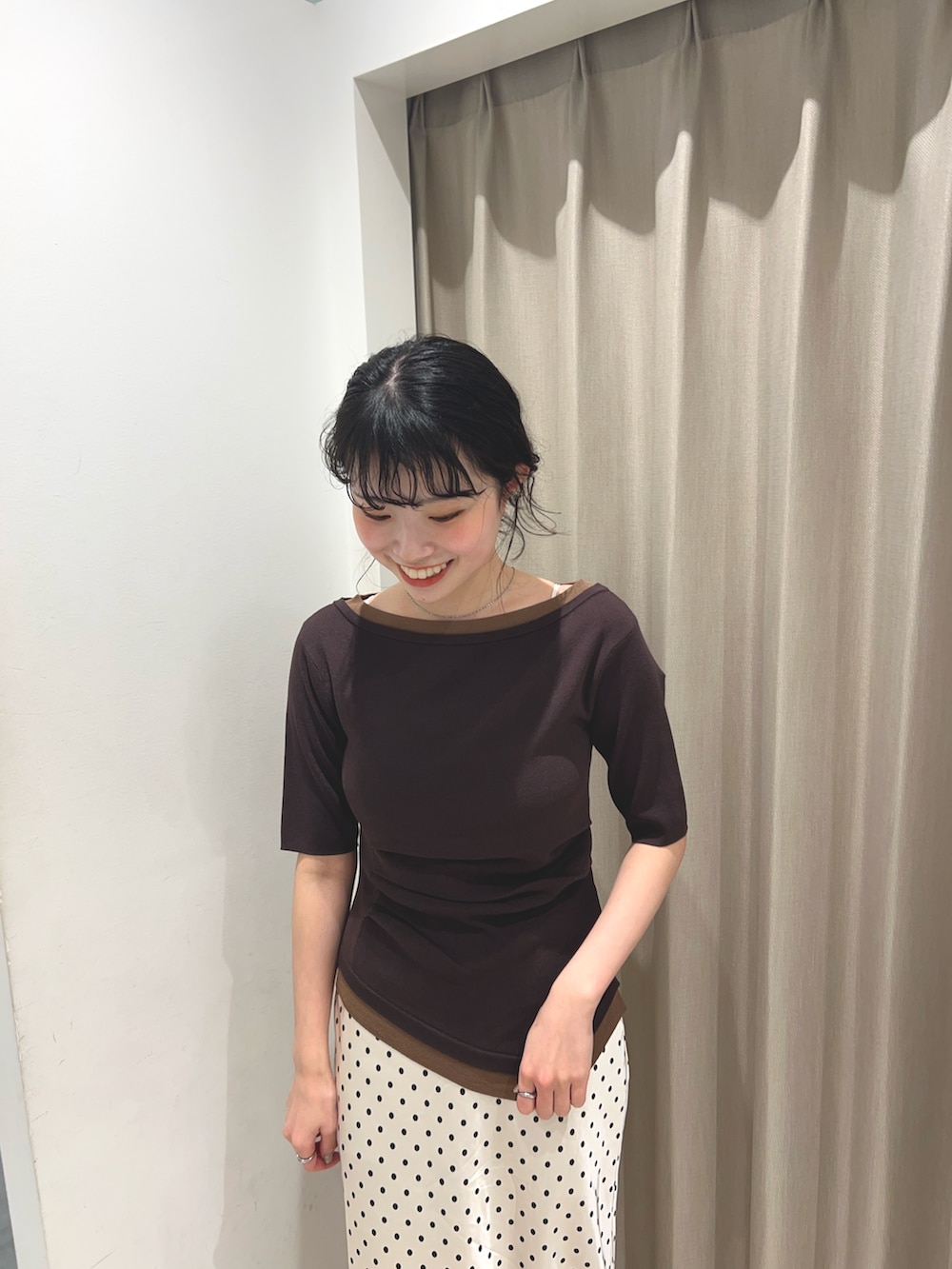 ブラウン系のニット/セーター、ホワイト系のスカート、ブラック系のローファーを着用したレディースの春コーディネートの3枚目の写真