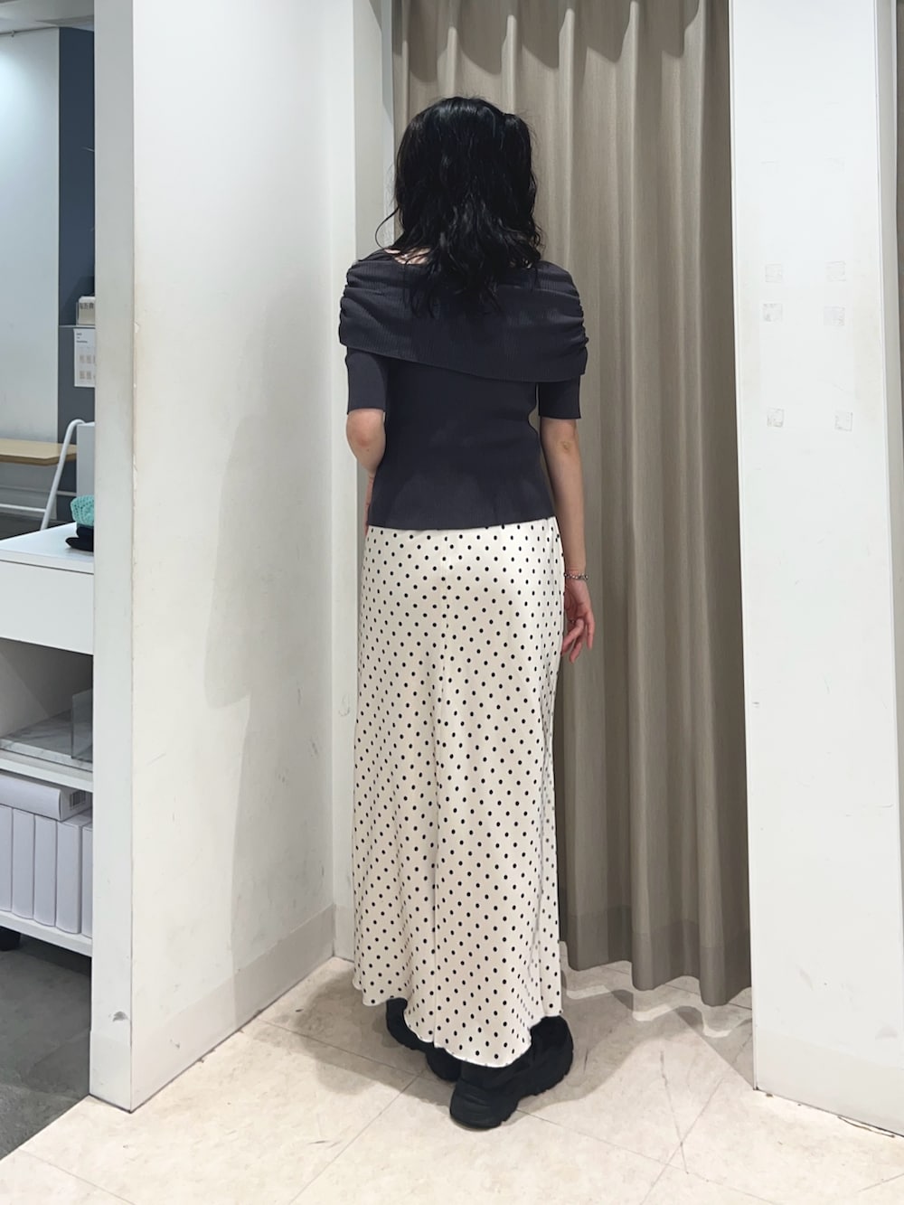 グレー系のニット/セーター、ホワイト系のスカートを着用したレディースの夏コーディネートの2枚目の写真