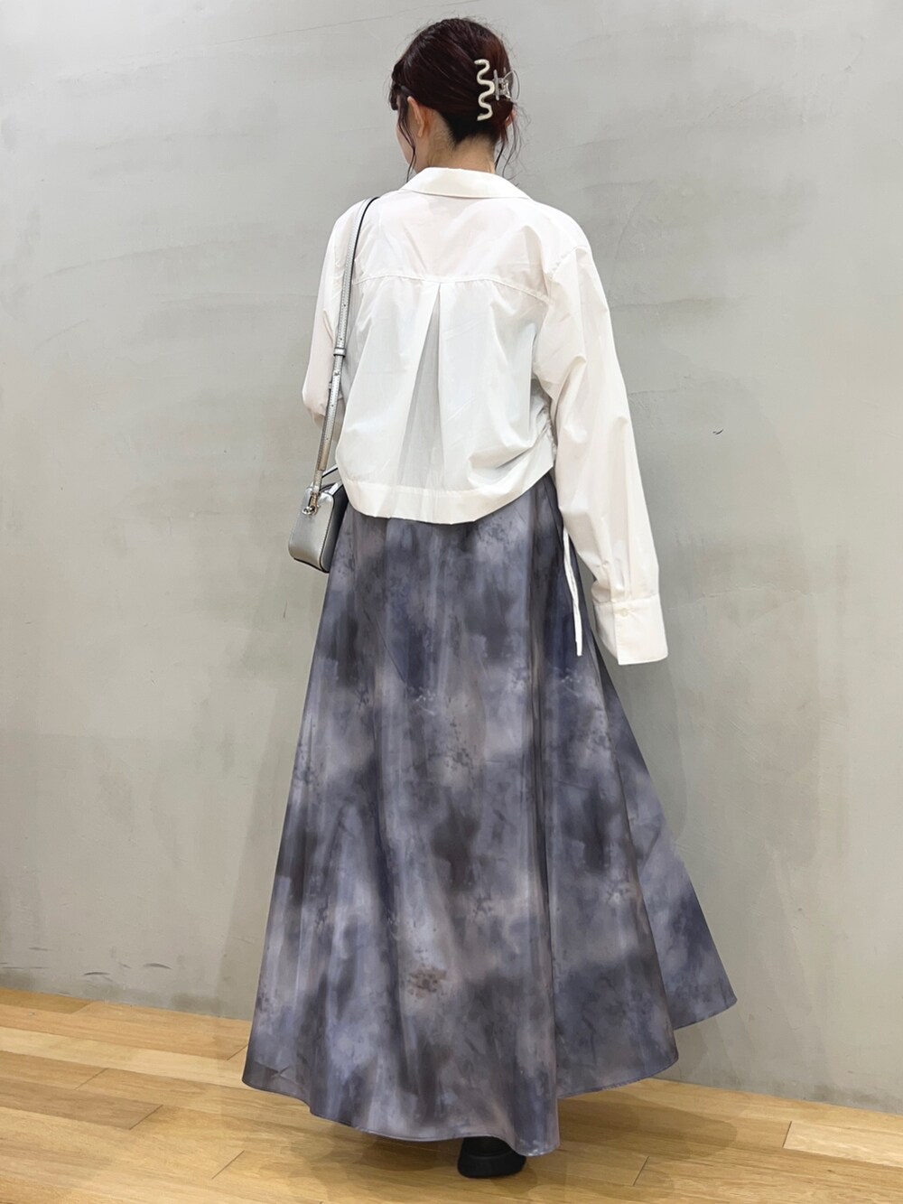 ブラック系のスカート、ホワイト系のシャツ/ブラウス、シルバー系のショルダーバッグを着用したレディースの春コーディネートの2枚目の写真