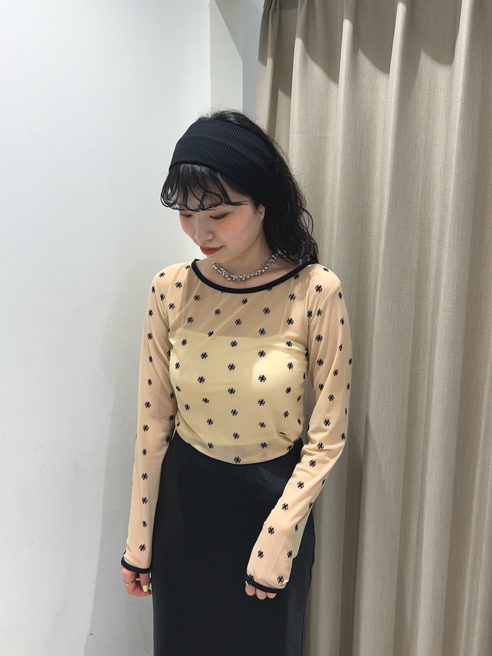 ベージュ系のTシャツ/カットソー、ブラック系のスカートを着用したレディースの春コーディネートの3枚目の写真