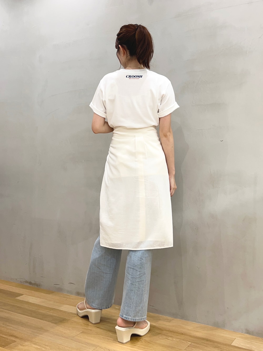 ブルー系のデニムパンツ、ホワイト系のシャツ/ブラウス、ホワイト系のサンダルを着用したレディースの夏コーディネートの2枚目の写真