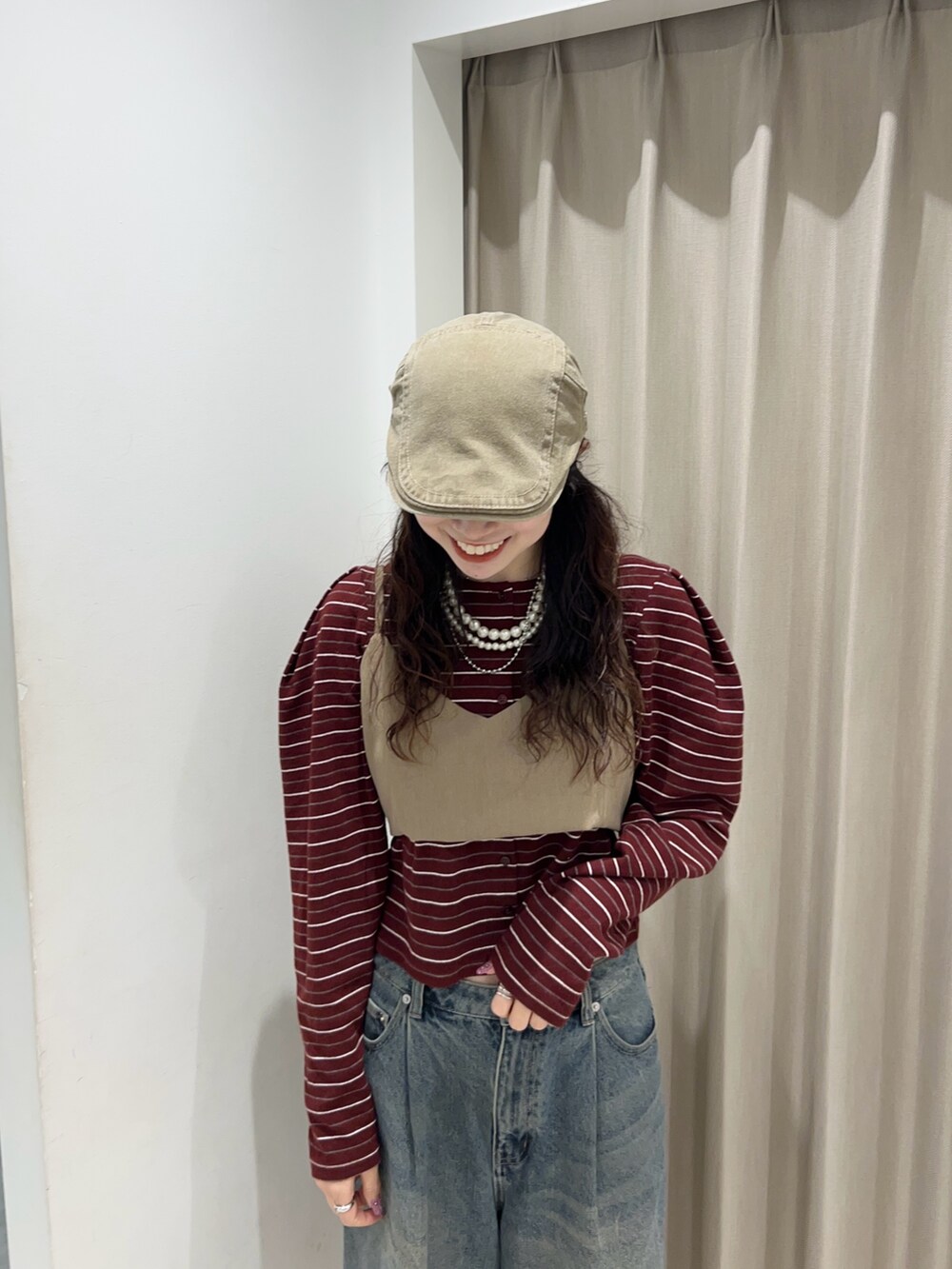 レッド系のカーディガン/ボレロ、ブルー系のデニムパンツを着用したレディースの秋コーディネートの3枚目の写真