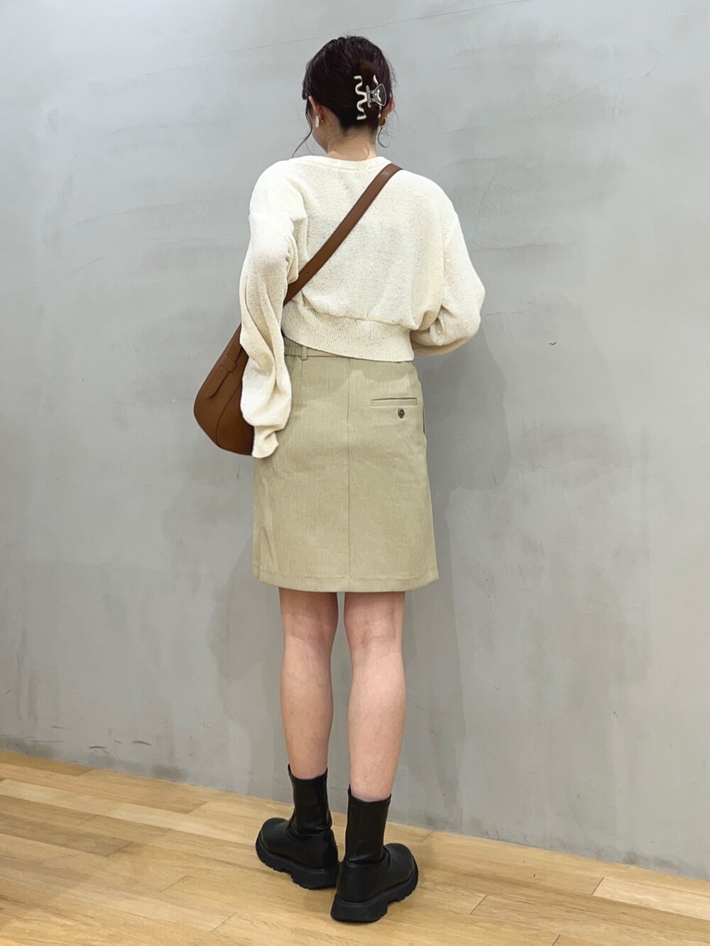 ベージュ系のスカート、ブラウン系のショルダーバッグ、ホワイト系のカーディガン/ボレロを着用したレディースの冬コーディネートの2枚目の写真