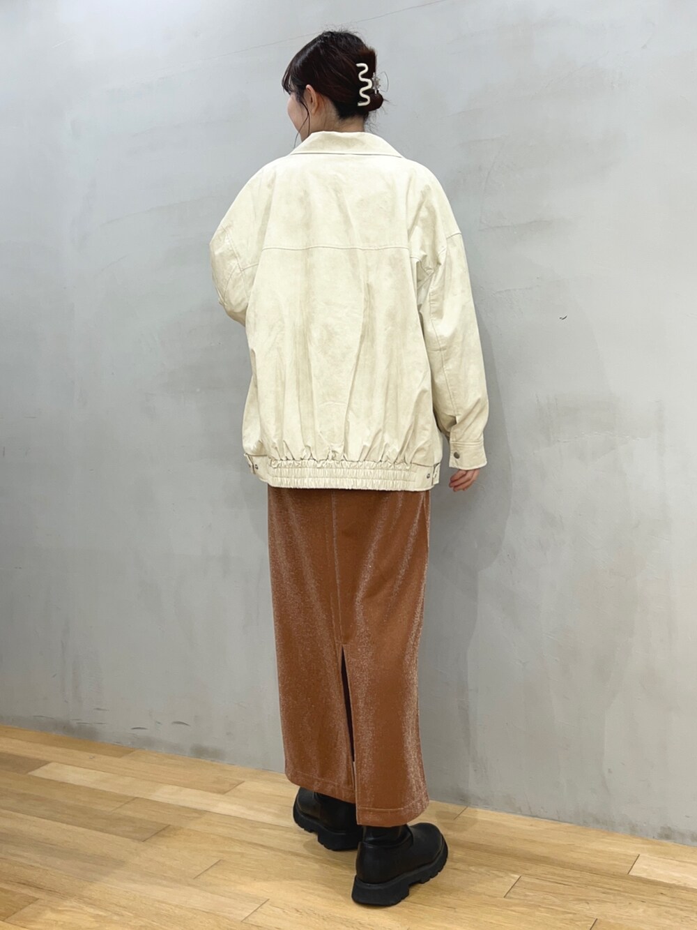 ブラウン系のスカート、ホワイト系のその他アウター、その他のスウェットを着用したレディースの冬コーディネートの2枚目の写真