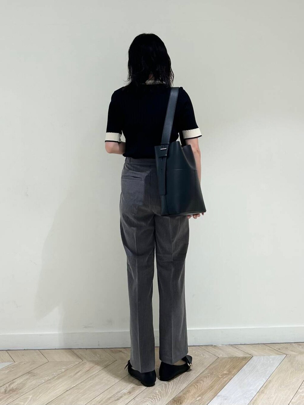 ブラック系のドレスシューズ、ブラック系のニット/セーター、グレー系のその他パンツを着用したレディースの夏コーディネートの2枚目の写真