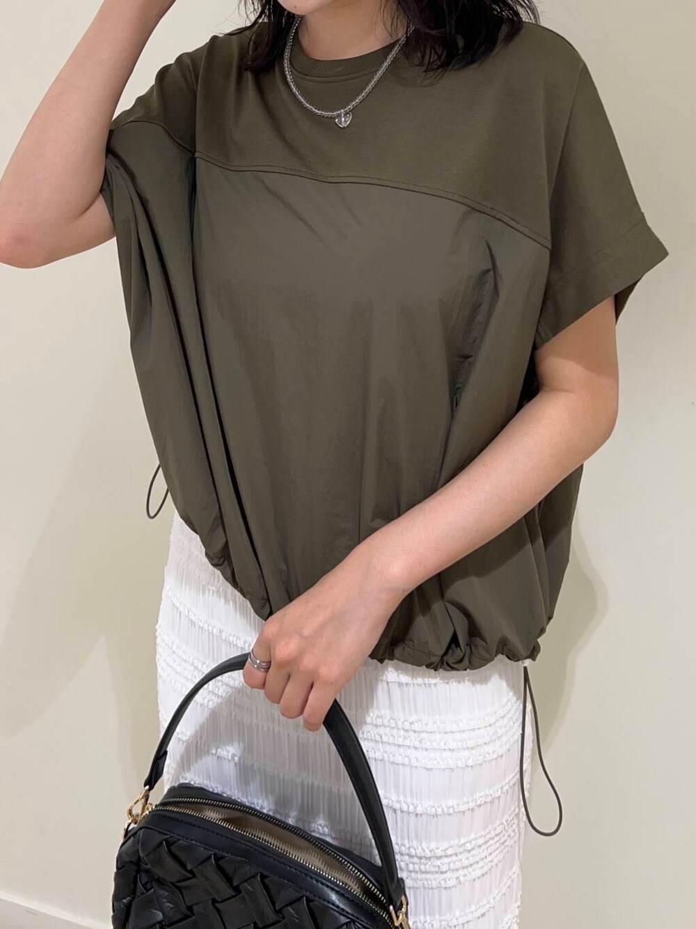 ホワイト系のスカート、ブラック系のサンダル、グリーン系のTシャツ/カットソーを着用したレディースの夏コーディネートの3枚目の写真