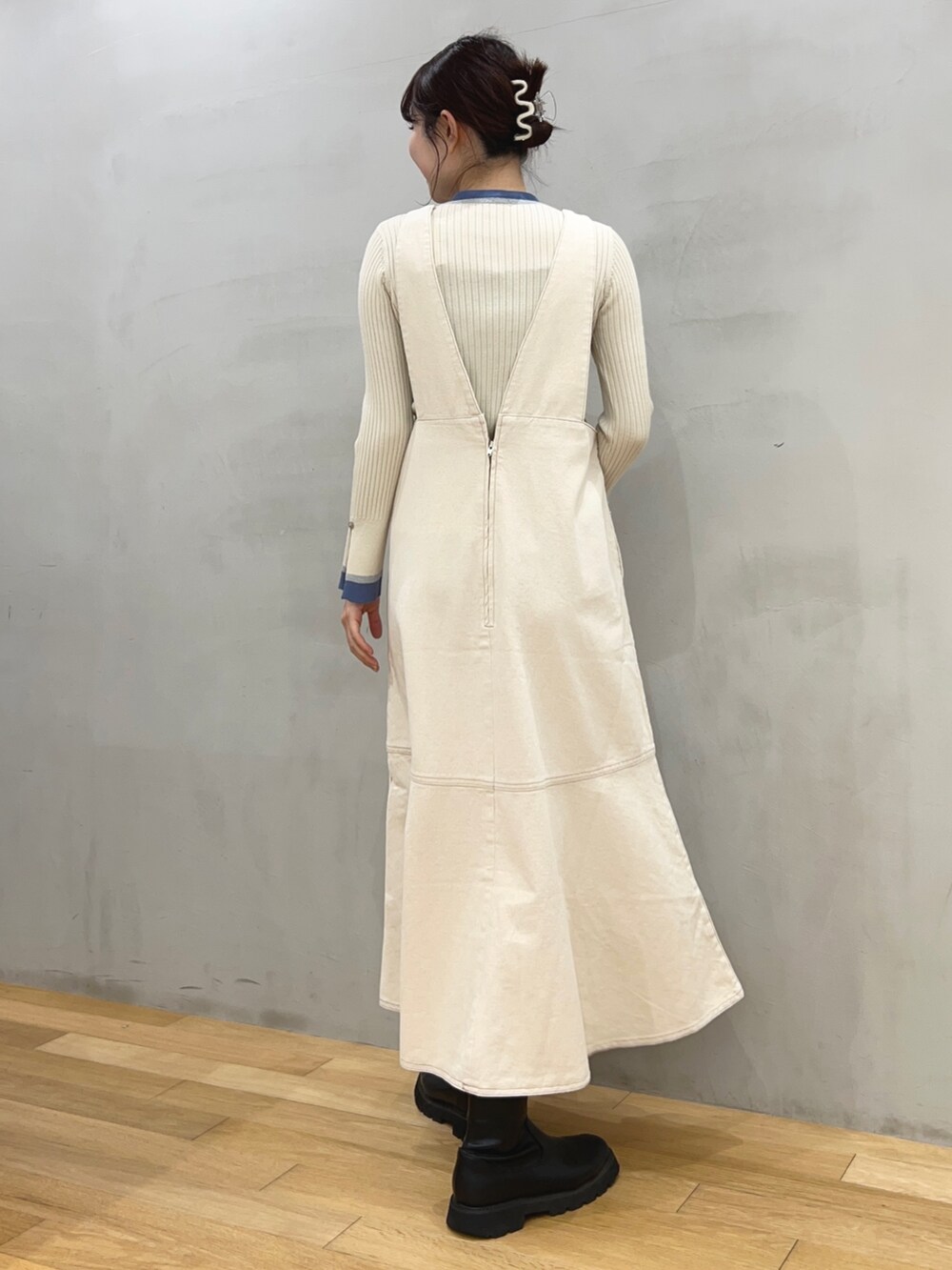 ホワイト系のショルダーバッグ、ホワイト系のジャンパースカート、ホワイト系のニット/セーターを着用したレディースの冬コーディネートの2枚目の写真