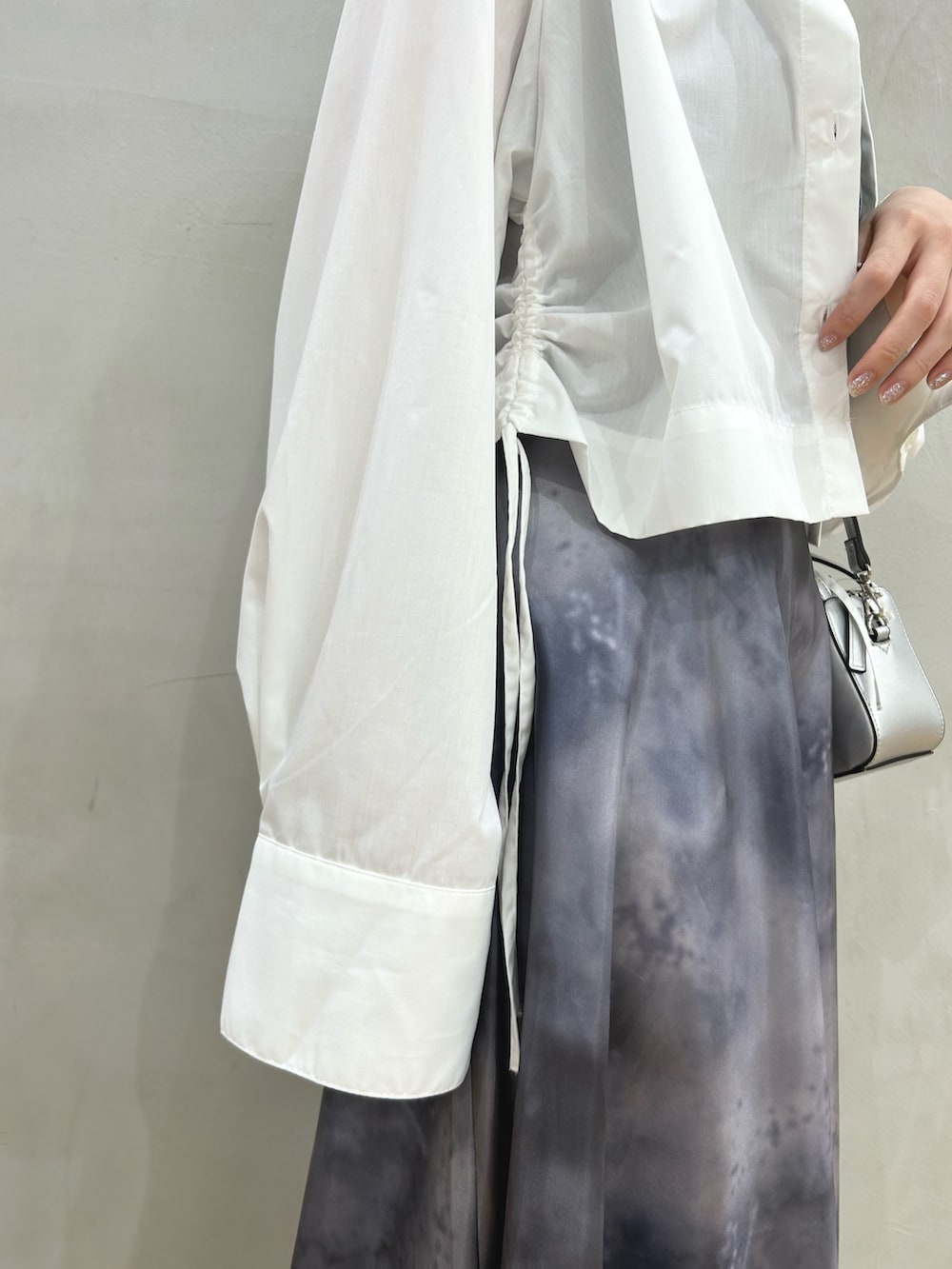 ブラック系のスカート、ホワイト系のシャツ/ブラウス、シルバー系のショルダーバッグを着用したレディースの春コーディネートの4枚目の写真