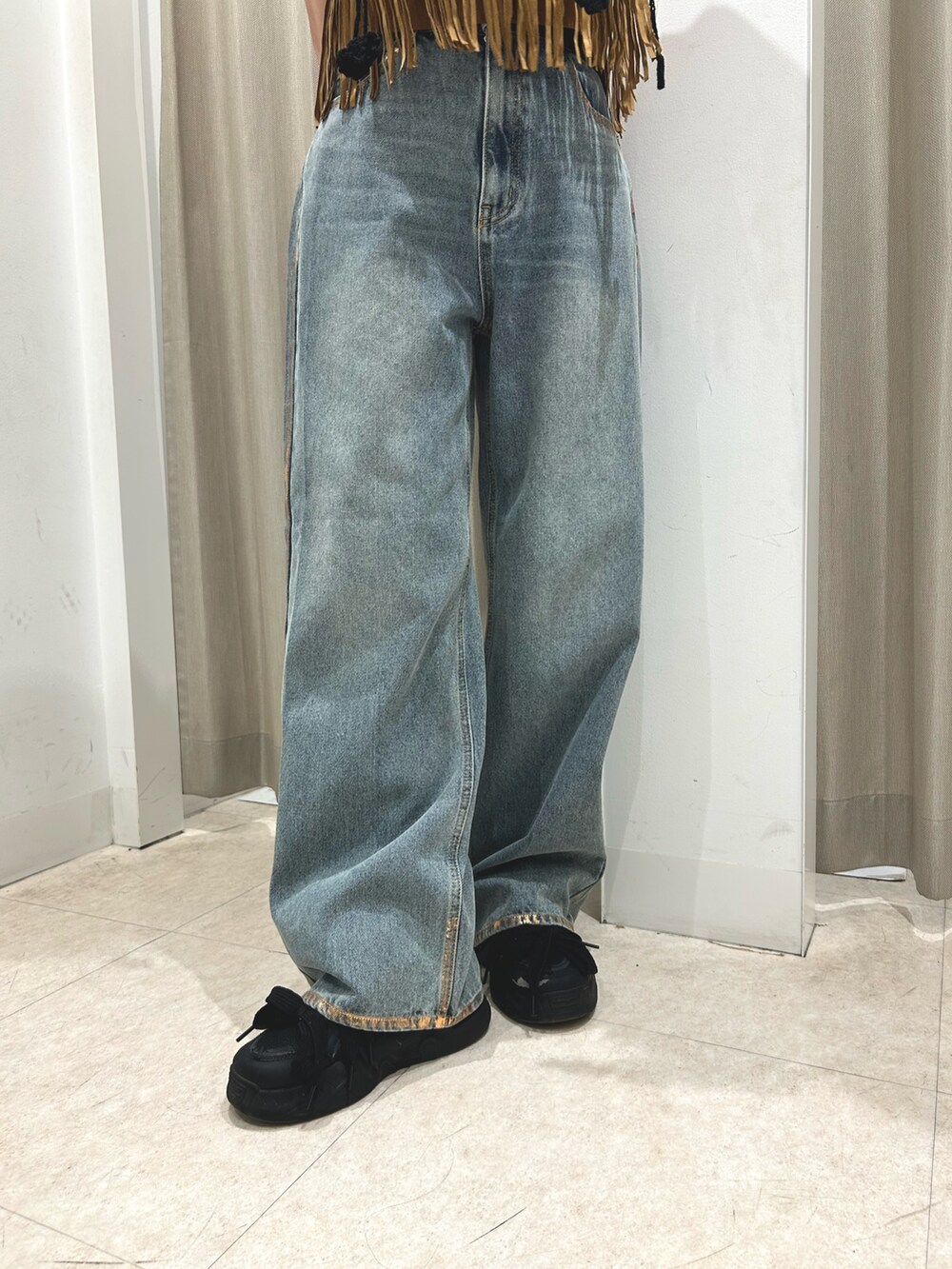 ブラック系のタンクトップ、ブルー系のデニムパンツ、イエロー系のキャミソールを着用したレディースの夏コーディネートの4枚目の写真