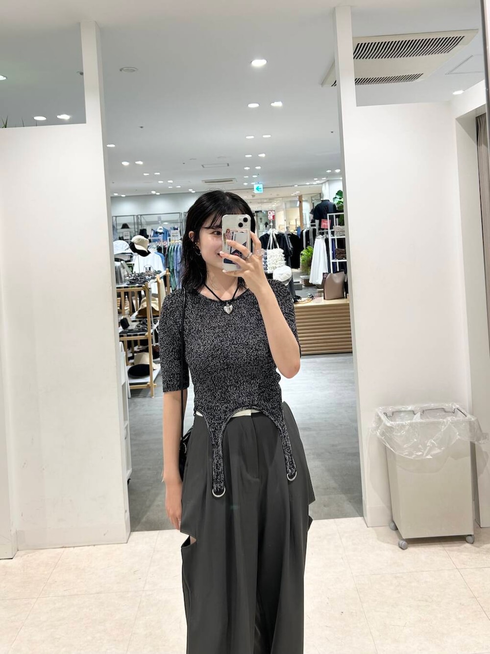 ブラック系のショルダーバッグ、ブラック系のニット/セーター、グレー系のその他パンツを着用したレディースの夏コーディネートの4枚目の写真