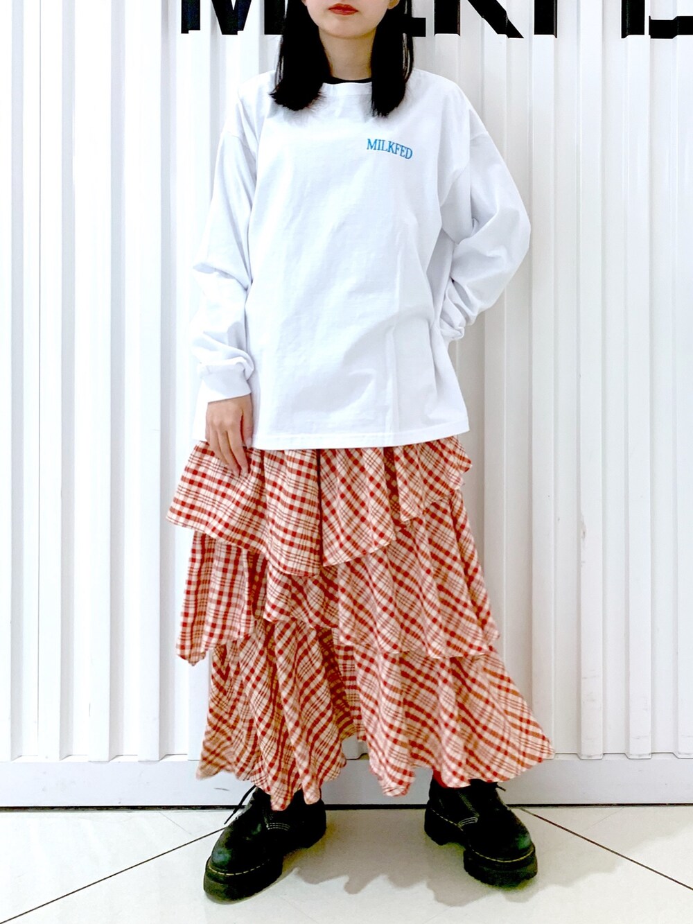 ホワイト系のTシャツ/カットソー、レッド系のスカート、レッド系のキャップを着用したレディースの冬コーディネートの5枚目の写真