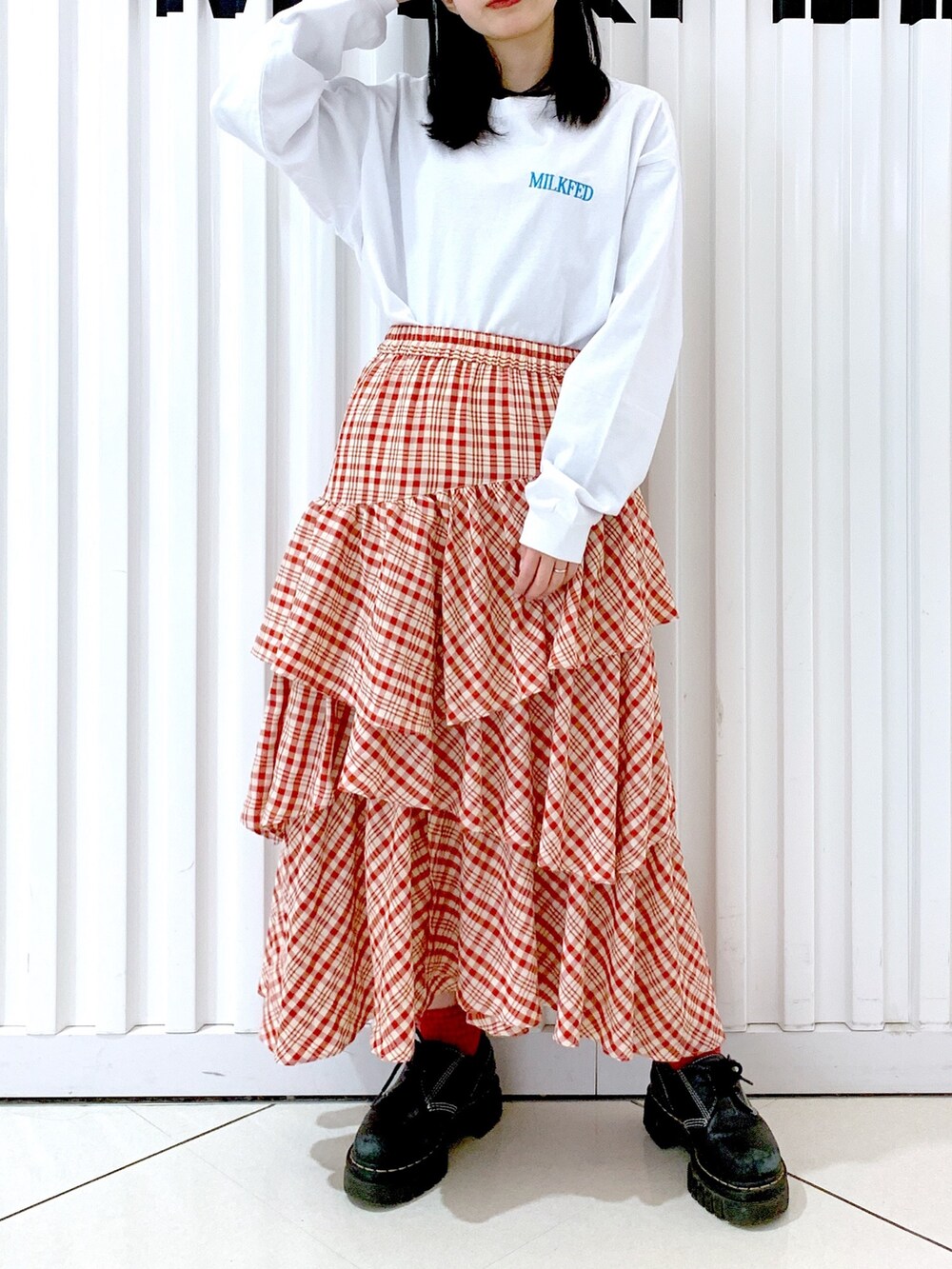 ホワイト系のTシャツ/カットソー、レッド系のスカート、レッド系のキャップを着用したレディースの冬コーディネートの2枚目の写真