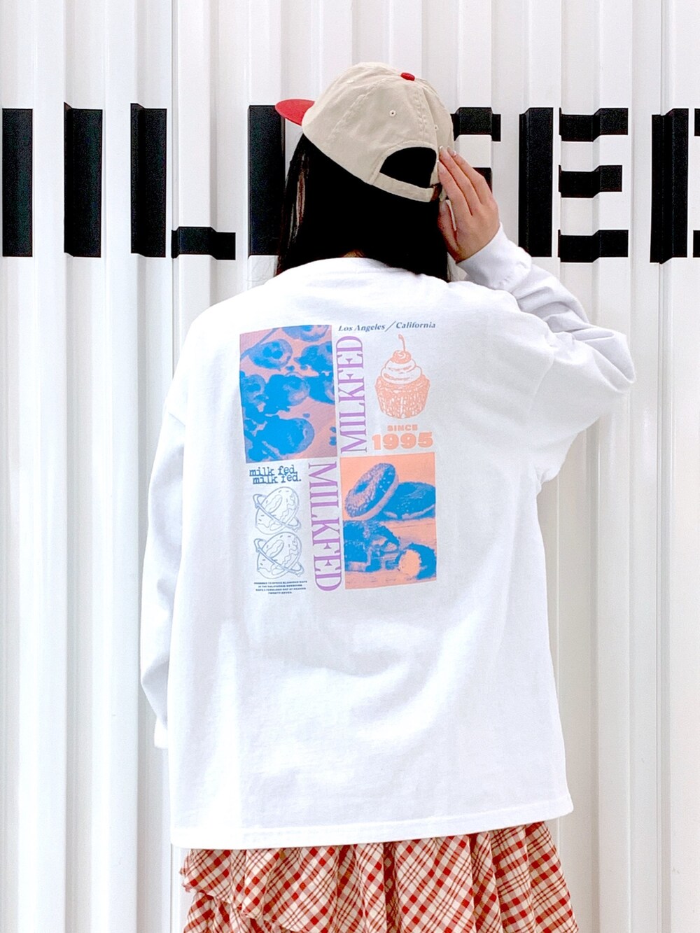 ホワイト系のTシャツ/カットソー、レッド系のスカート、レッド系のキャップを着用したレディースの冬コーディネートの6枚目の写真