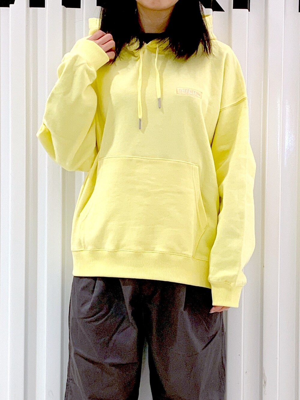 グレー系のその他パンツ、イエロー系のパーカー、オレンジ系のキャップを着用したレディースの冬コーディネートの5枚目の写真