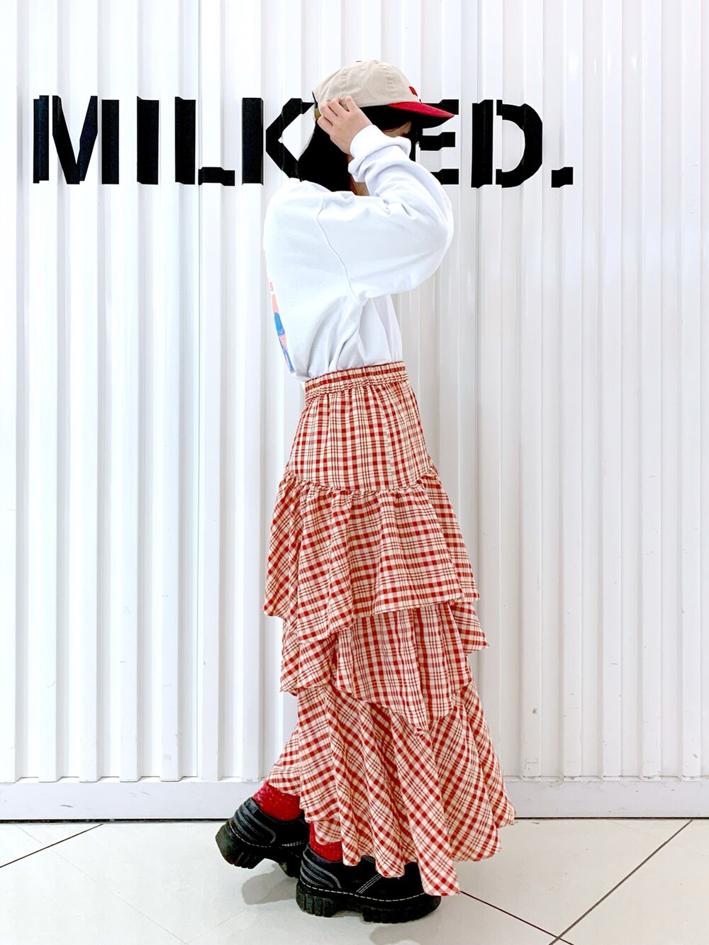 ホワイト系のTシャツ/カットソー、レッド系のスカート、レッド系のキャップを着用したレディースの冬コーディネートの3枚目の写真