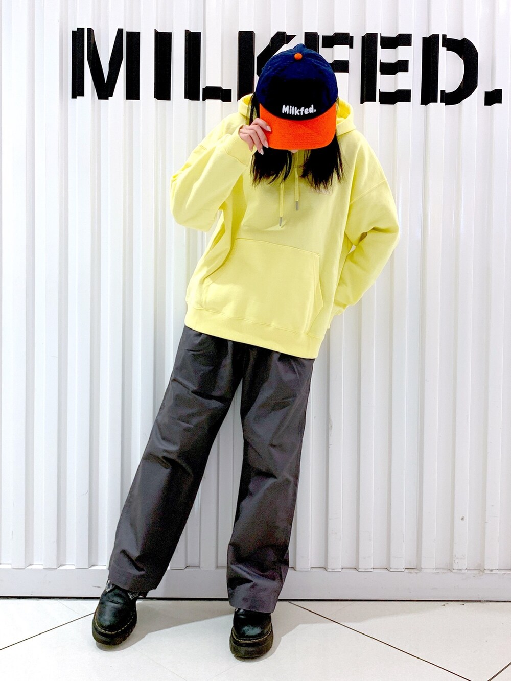 グレー系のその他パンツ、イエロー系のパーカー、オレンジ系のキャップを着用したレディースの冬コーディネートの3枚目の写真