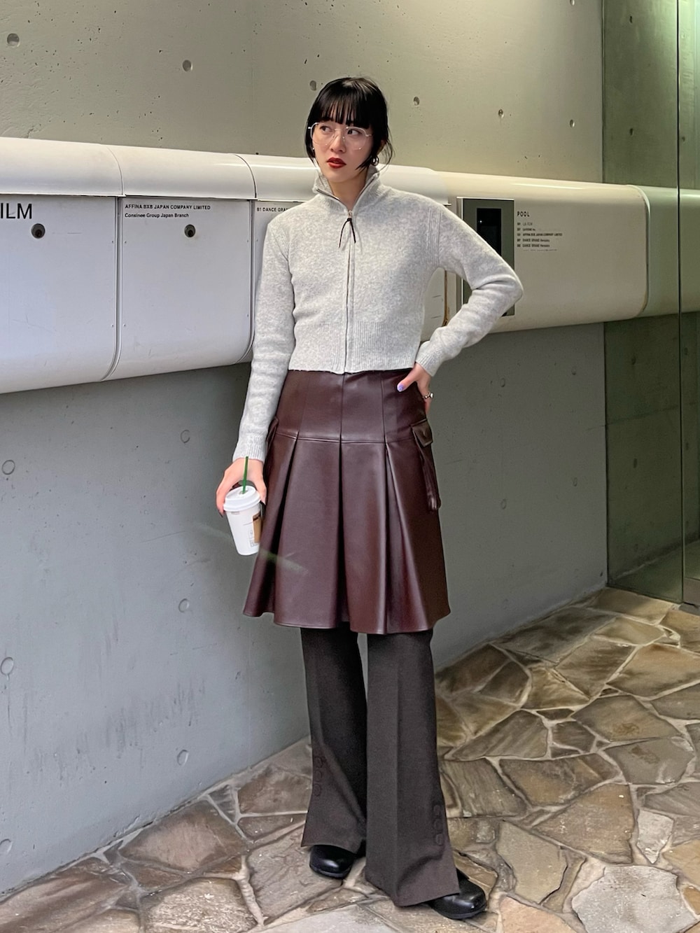 ブラック系のローファー、ブラウン系のスカート、ブラウン系のパンツを着用したレディースの秋コーディネートの2枚目の写真