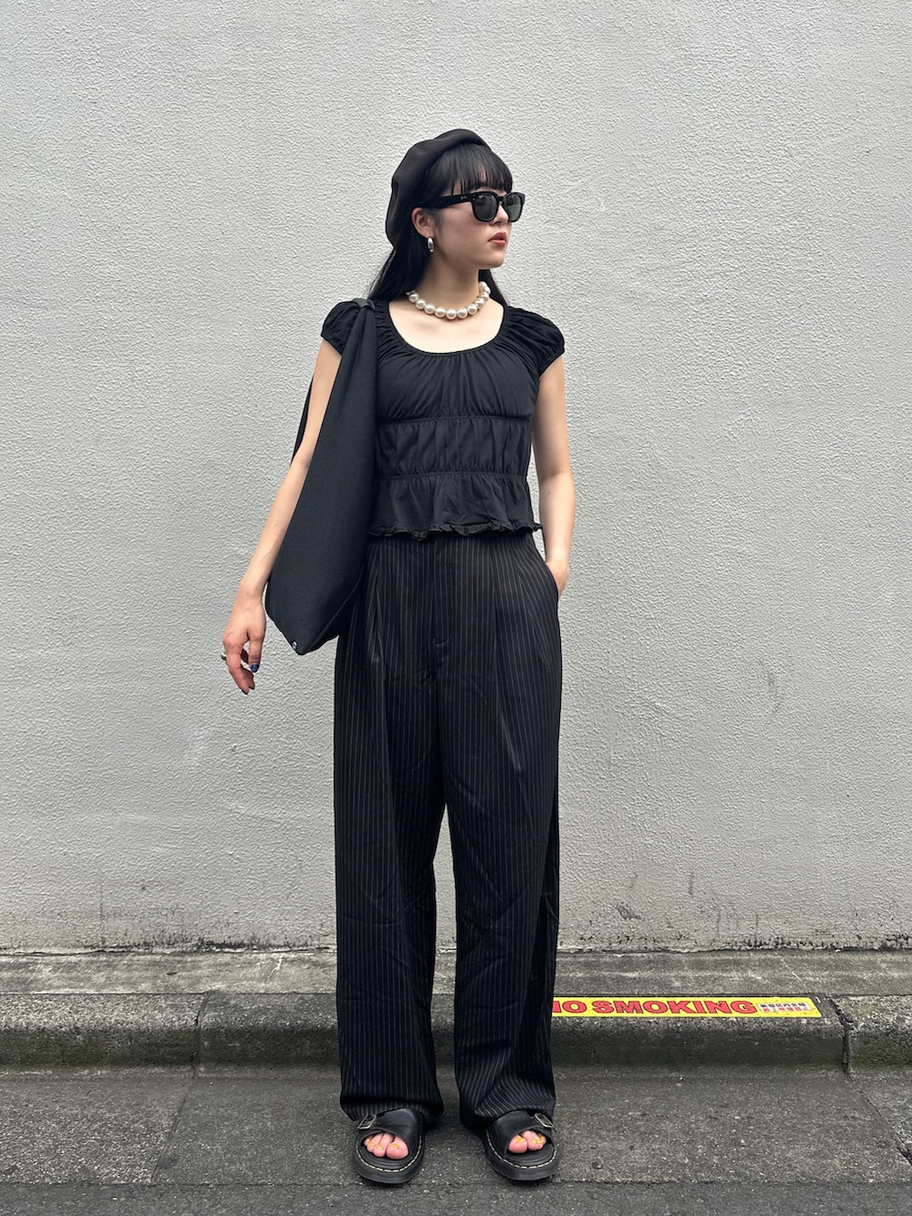 ブラック系のTシャツ/カットソー、ブラック系のハンドバッグ、ブラック系のサンダルを着用したレディースの夏コーディネートの2枚目の写真