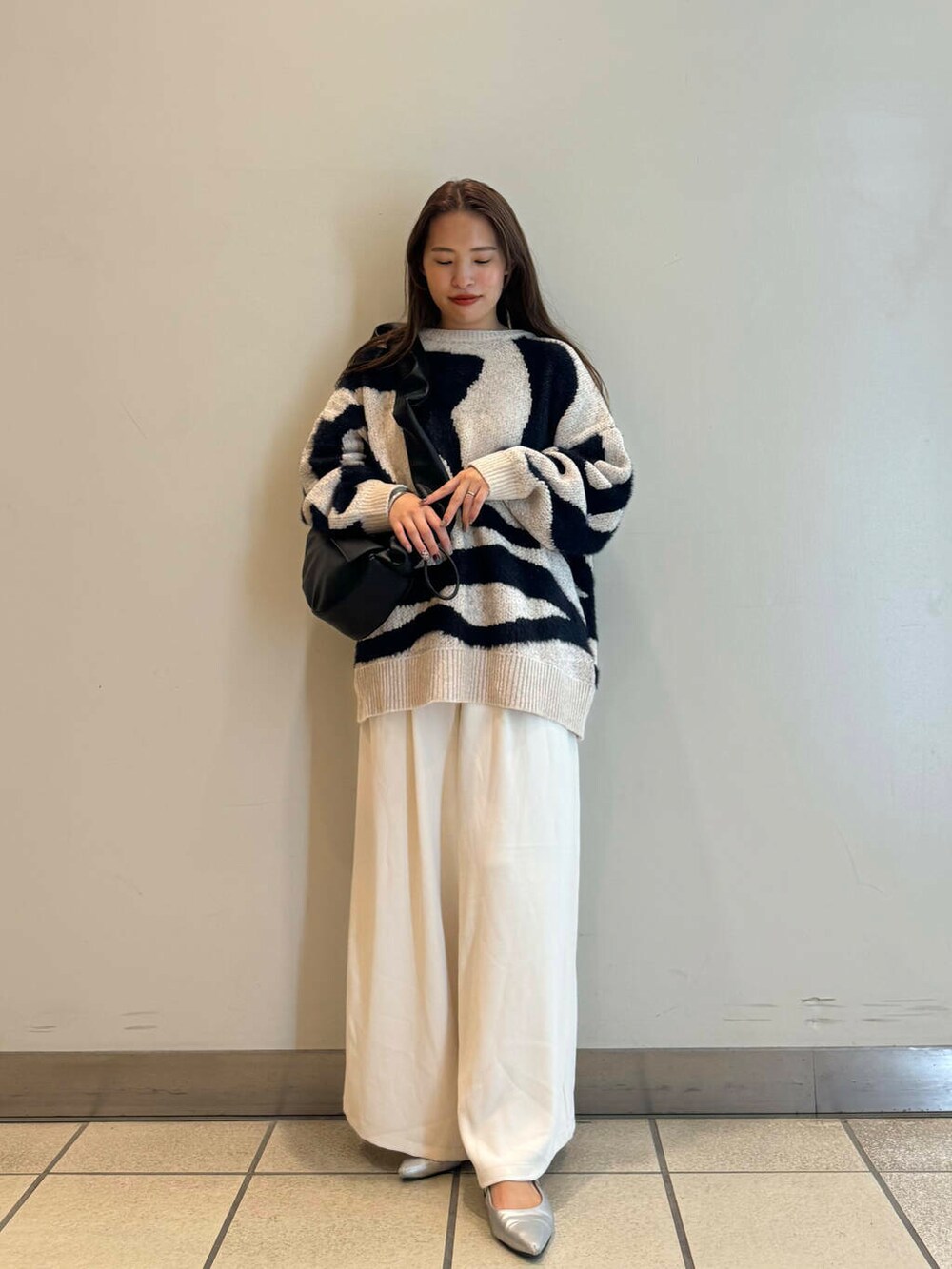 ブラック系のハンドバッグ、ホワイト系のその他パンツ、ホワイト系のニット/セーターを着用したレディースの秋コーディネートの3枚目の写真