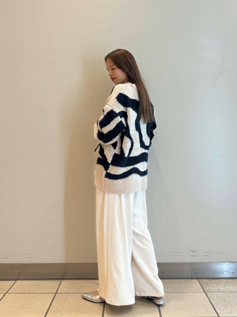 ブラック系のハンドバッグ、ホワイト系のその他パンツ、ホワイト系のニット/セーターを着用したレディースの秋コーディネートの2枚目の写真