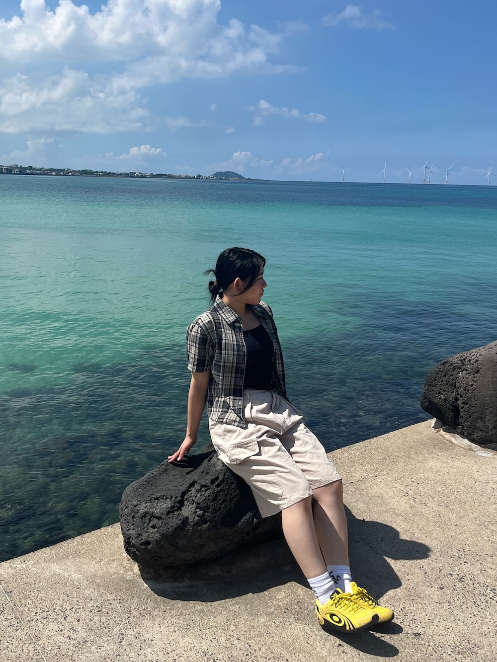 ブラック系のシャツ/ブラウス、ベージュ系のチノパンツ、イエロー系のスニーカーを着用したレディースの冬コーディネートの2枚目の写真