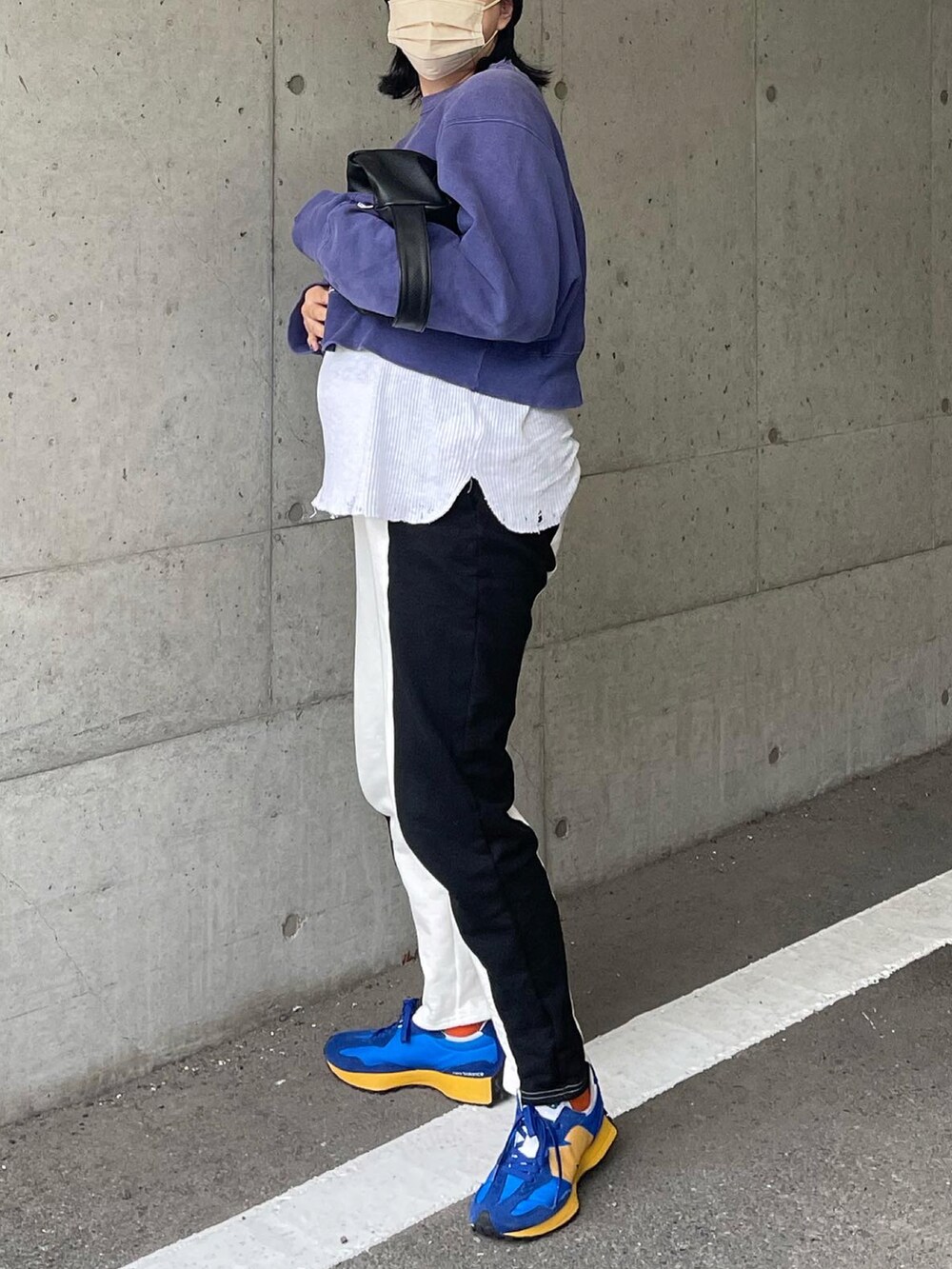 ブルー系のスウェット、ブラック系のハンドバッグ、ホワイト系のTシャツ/カットソーを着用したレディースの冬コーディネートの2枚目の写真