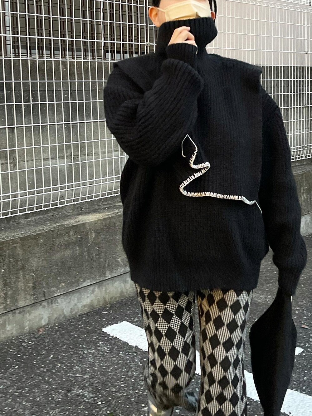 ブラック系のニット/セーター、ブラック系のハンドバッグ、ブラック系のその他パンツを着用したレディースの冬コーディネートの2枚目の写真