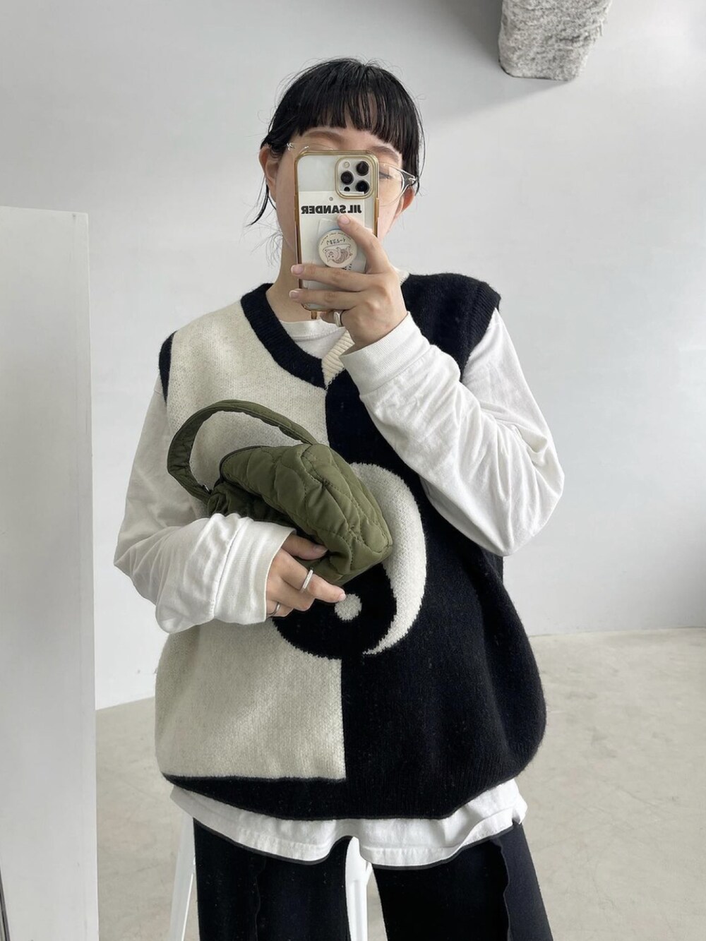 ホワイト系のベスト、ブラック系のその他パンツ、ホワイト系のスニーカーを着用したレディースの秋コーディネートの2枚目の写真