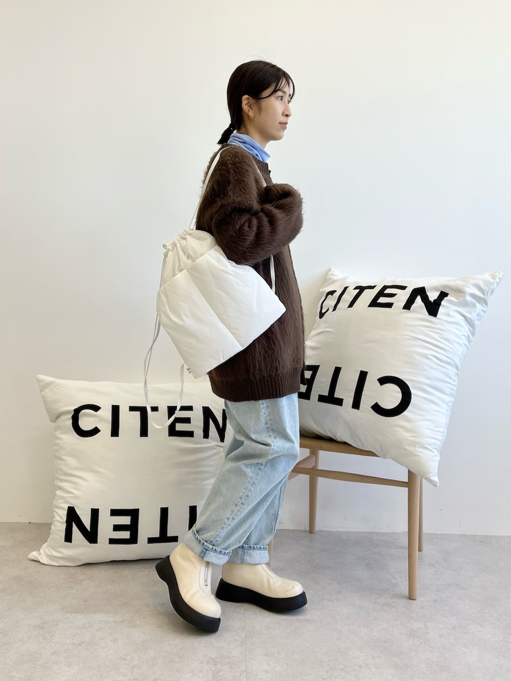 ブラウン系のカーディガン/ボレロ、ブルー系のTシャツ/カットソー、ブルー系のデニムパンツを着用したレディースの秋コーディネートの2枚目の写真