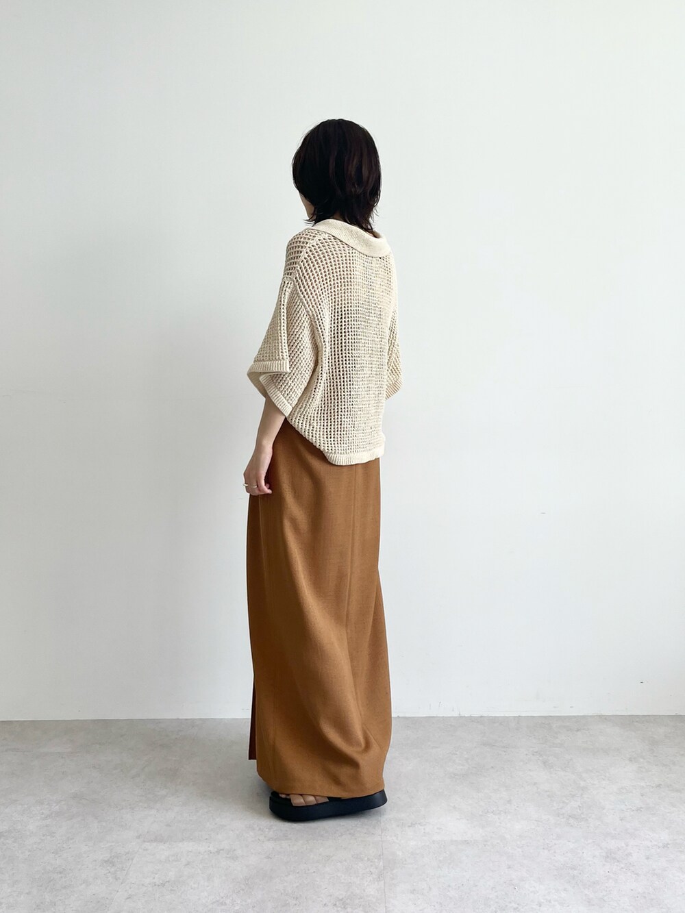 ブラック系のニット/セーター、イエロー系のスカート、ベージュ系のニット/セーターを着用したレディースの春コーディネートの3枚目の写真