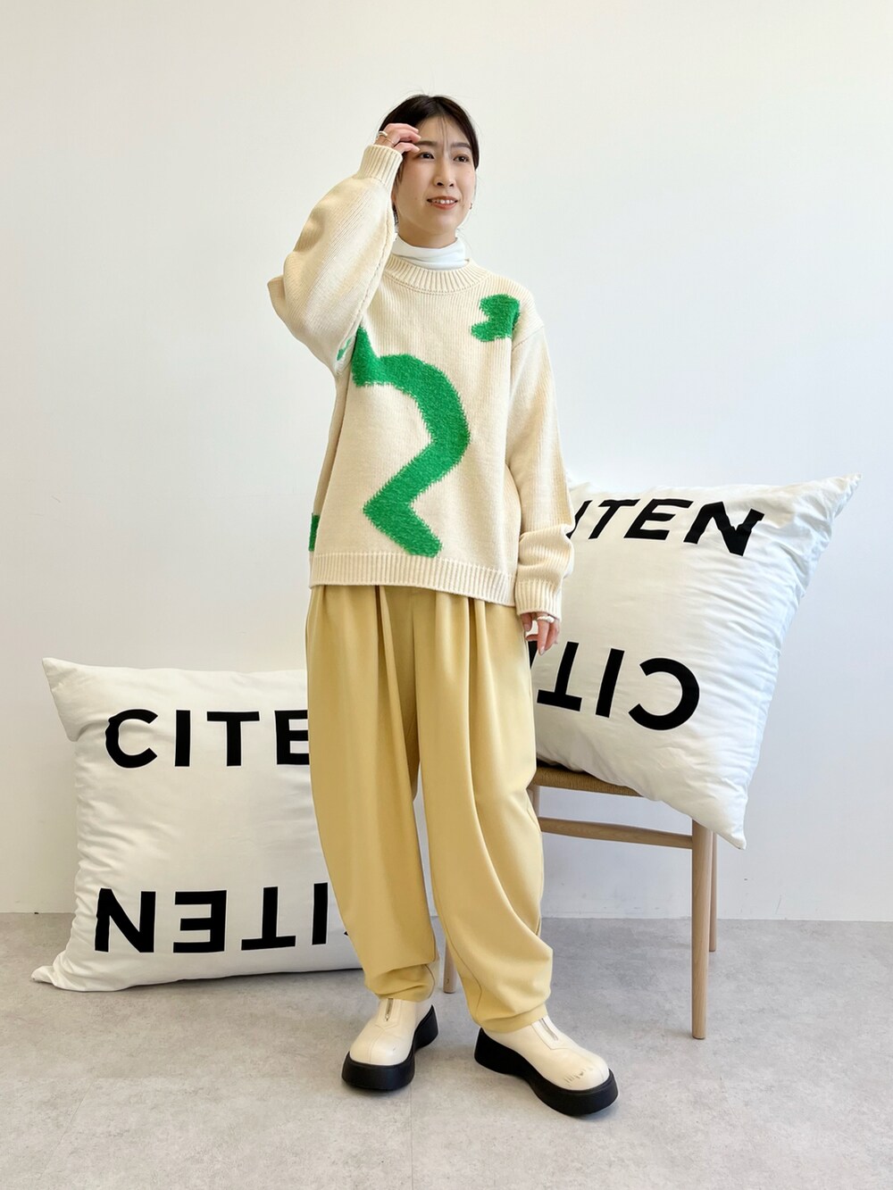 ブラウン系のステンカラーコート、ホワイト系のTシャツ/カットソー、ホワイト系のトップスを着用したレディースの秋コーディネートの4枚目の写真