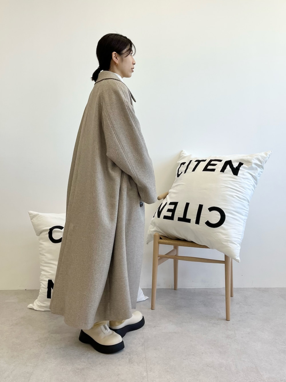 ブラウン系のステンカラーコート、ホワイト系のTシャツ/カットソー、ホワイト系のトップスを着用したレディースの秋コーディネートの2枚目の写真