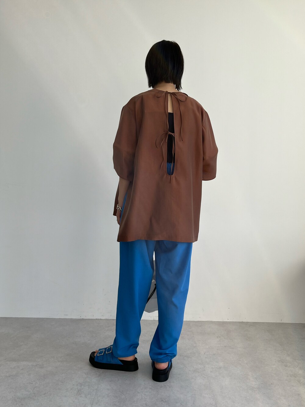 ブラウン系のシャツ/ブラウス、ブルー系のその他パンツ、ホワイト系のショルダーバッグを着用したレディースの春コーディネートの3枚目の写真