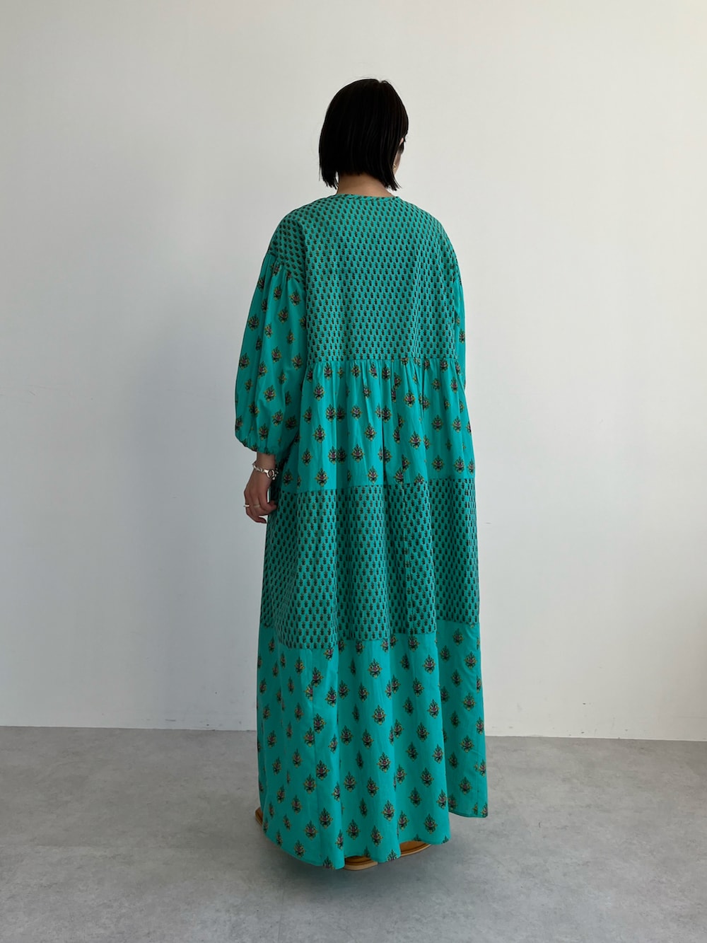 グリーン系のワンピース、ブラウン系のサンダルを着用したレディースの春コーディネートの3枚目の写真