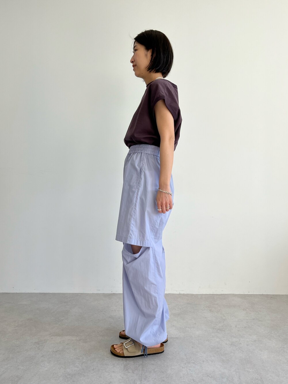 ブラウン系のTシャツ/カットソー、ブルー系のその他パンツ、ベージュ系のサンダルを着用したレディースの春コーディネートの2枚目の写真