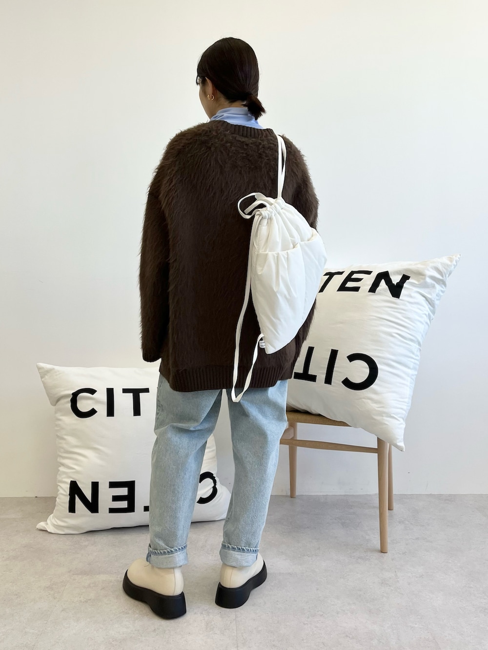 ブラウン系のカーディガン/ボレロ、ブルー系のTシャツ/カットソー、ブルー系のデニムパンツを着用したレディースの秋コーディネートの3枚目の写真