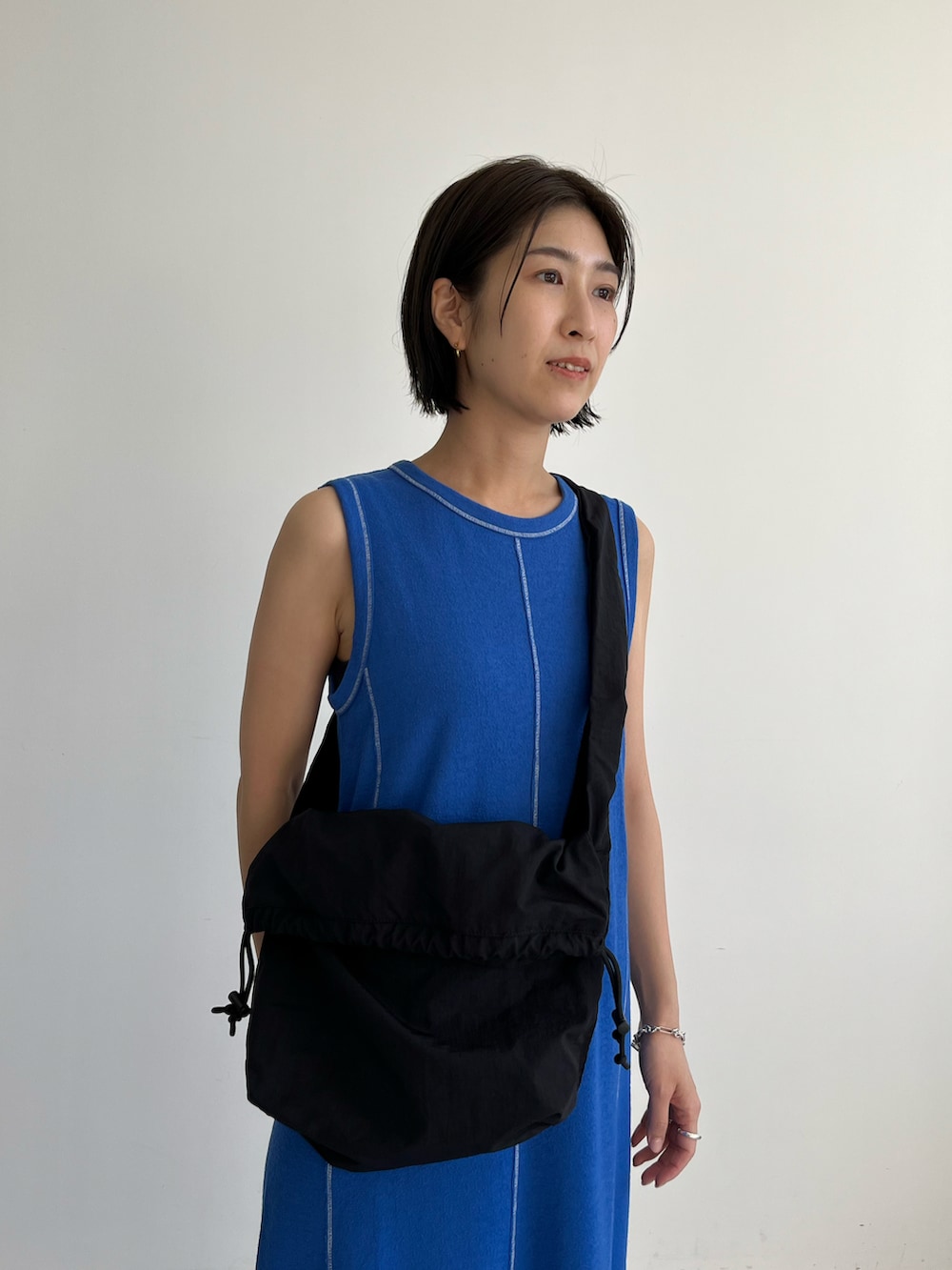 ブルー系のワンピース、ブラック系のショルダーバッグ、ブラック系のサンダルを着用したレディースの春コーディネートの3枚目の写真